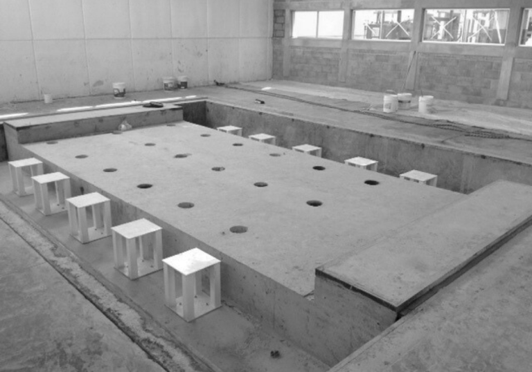 Proceso de grouteo y alineación para maquinaria industrial en cimentación especializada.