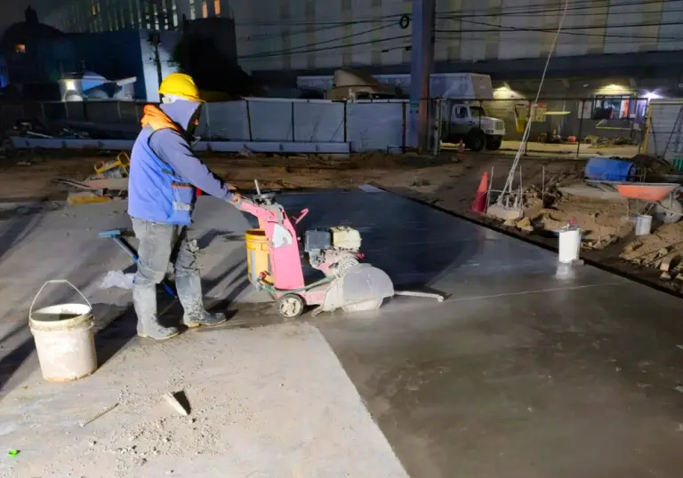 Técnico realizando aplanado de superficies con acabado uniforme en un espacio industrial.