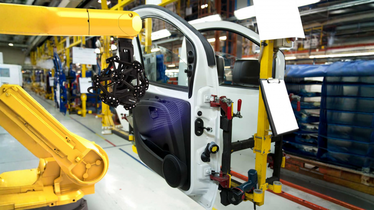 Escáner metrológico midiendo puerta automotriz en línea de producción.