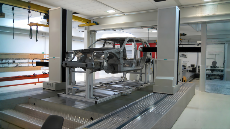 Sistema CMM midiendo carrocería automotriz en laboratorio de metrología.